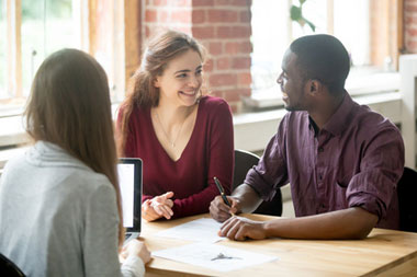 Diverse group discussing mortgage options with advisor, showcasing flexible Non-QM loans for self-employed in New York and Pennsylvania